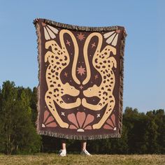 a person standing in front of a large tapestry