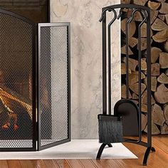 a fireplace with logs and a fire place in the corner, next to it is an iron screen