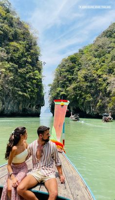 a man and woman sitting on the back of a boat in a body of water