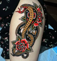 a snake and rose tattoo on the thigh