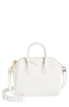 Beloved by street-style mavens the world over, Givenchy's Antigona satchel is updated in a chic, compact size. Top zip closure Top carry handles; removable, adjustable shoulder strap Interior zip and wall pockets Structured silhouette with flat base and protective leather feet Leather Made in Italy Designer Handbags White Shoulder Bag With Zipper Closure For Evening, White Evening Bag With Zipper Closure, White Top Handle Satchel With Zipper Closure, White Formal Shoulder Bag With Zipper Closure, Formal White Shoulder Bag With Zipper Closure, Modern White Satchel With Zipper Closure, White Designer Satchel For Formal Occasions, Elegant White Satchel With Zipper Closure, White Modern Satchel For Formal Occasions