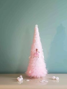 a pink christmas tree with white balls around it