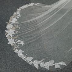 a wedding veil with flowers and leaves on it