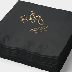 black and gold foiled paper napkins with the words fifty on them, set against a white background