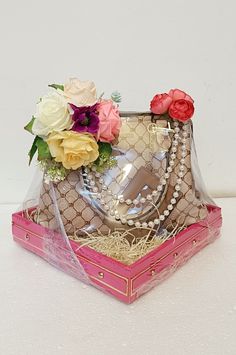 a purse with flowers in it sitting on top of a box