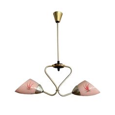 three light pink and gold chandelier with two lights hanging from the bottom to the ceiling