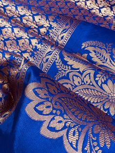 Gorgeous Statement designer Saree in Royal Blue color with Muted Gold Zari Weaving. Saree has Floral Motifs all over with design pattern borders with big flower buttas. Item : SareeColor : Royal Blue Base Fabric : Banarasi Silk Blouse material : Soft Banarasi Silk Work : Handloom Blue Handloom Lehenga For Traditional Ceremonies, Royal Blue Saree With Zari Weaving For Diwali, Royal Blue Saree For Puja And Diwali, Royal Blue Saree For Diwali Puja, Blue Semi-stitched Blouse With Traditional Patterns, Blue Tussar Silk Lehenga With Traditional Patterns, Blue Art Silk Blouse Piece With Traditional Patterns, Royal Blue Banarasi Silk Dupatta For Puja, Semi-stitched Blue Blouse With Traditional Patterns