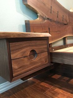 a wooden bed frame with two drawers on the bottom