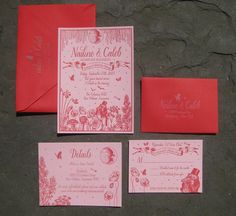 red and pink wedding stationery with matching envelopes, cards and papers on concrete