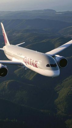 an airplane flying in the sky over some mountains