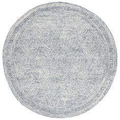 a round rug with an intricate design on the center and bottom, in grey tones