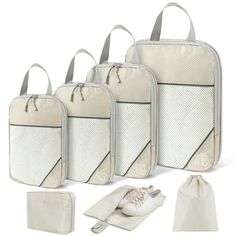 four pieces of white luggage with one bag and three pairs of shoes next to it