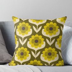 a green and yellow flowered pillow on a couch