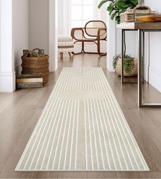 a long white rug in the middle of a room with a chair and potted plant