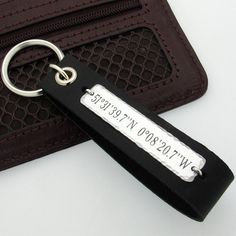 a keychain with a name tag on it sitting next to an empty wallet