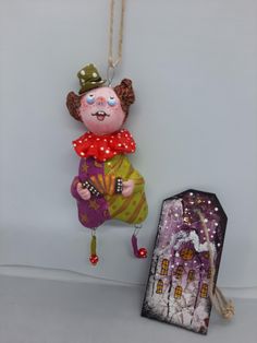 an ornament is hanging on the wall next to a small box with a doll in it