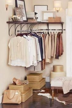 a closet with clothes and shoes hanging on the wall next to a chair in front of it