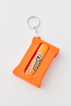 an orange keychain with a can of soda in the shape of a rectangle