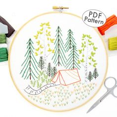 the embroidery pattern is being worked on with scissors and thread, along with other sewing supplies