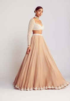 Editor's Note Radiate elegance in this captivating beige pearl embellished lehenga, perfectly complemented by a sweetheart neck pearl drop full sleeve blouse. The intricate pearl detailing adds...