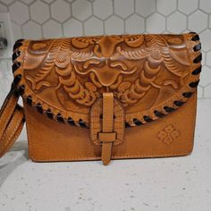 Patricia Nash Lanza Tooled Leather Convertible Crossbody Wristlet Bag Browncarry It As A Crossbody Or A Clutch. 100% Full-Grain Leather Interior: 1 Center Zip Compartment, 6 Credit Card Slots, 1 Zip Pocket, 2 Slip Pockets; 100% Polyester Exterior: 1 Rear Zip Pocket, 1 Slip Pocket Under Front Flap Push-Lock Closure Signature Brushed Metal Hardware, Heavy Handcrafted Stitching. Dimensions: 9"(W) X 7"(H) X 2 3/4"(D) Strap Drop: 23" - 26" Brown Leather Clutch With Detachable Handle, Handheld Leather Pouch With Adjustable Strap, Leather Rectangular Pouch With Detachable Handle, Rectangular Leather Pouch With Detachable Handle, Leather Crossbody Clutch With Mobile Phone Bag, Leather Crossbody Clutch With Phone Bag, Brown Leather Clutch With Mobile Phone Bag, Elegant Leather Clutch With Hand Tooled Details, Leather Top Handle Clutch