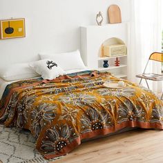 a bedroom with a bed covered in an orange and black comforter next to a window