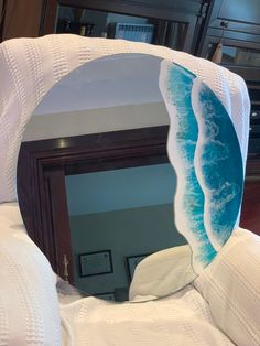 a mirror that is sitting on top of a white bedding with waves coming out of it