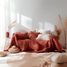 a bed covered in red sheets and pillows