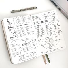 an open notebook with writing on it next to a pencil and some other things in the background