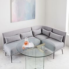 a living room with a couch, coffee table and vases on the glass tables