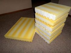 several pieces of yellow cake sitting on the floor in front of a wall and carpet