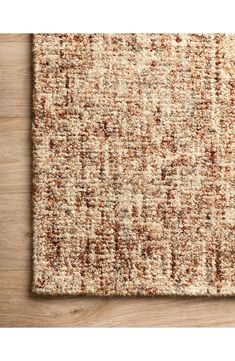 an area rug with brown and tan colors on top of a wooden flooring surface