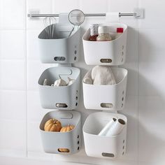 a white wall mounted shelf filled with containers and utensils