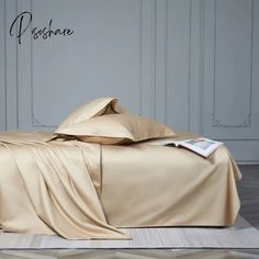 an image of a bed that is made up with sheets and pillows on top of it