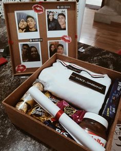 an open box filled with personal items on top of a table next to pictures and photos