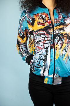 "You'll love this Basquiat Bomber jacket, it supports your active lifestyle and helps to be more stylish. And be ready to receive compliments as it will for sure attract everyone's attention :) !!PAY ATTENTION TO THE SIZE CHART!! Material: 80% polyester, 20% cotton with soft fleece lining inside. Sizes: XS, S, M, L, XL, XXL The item is made to order, our production time is 4-5 days. Model's measurements 93-67-83 cm. Height 167 cm. Also, we will be happy to print your own image on the bomber. Jus Trendy Graphic Print Track Jacket For Streetwear, Trendy Hand Painted Outerwear For Streetwear, Hand Painted Blue Outerwear For Streetwear, Blue Hand Painted Outerwear For Streetwear, Artistic Graffiti Print Outerwear For Streetwear, Rave Clothes, Graffiti Font, Spray Paint Art, Festival Clothing