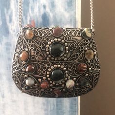 This Handcrafted Evening Bag Is A Perfect Way To Add Old-World Charm To Your Wardrobe. Known As A Sajai, Which Means To Decorate Or Beautify, This Gorgeous Handbag Is Decorated With Multi-Colored Agate Stones. The Agate Stones Are Mined From The Western Coast Of India. Bag Is About 4"H X 5"L X 2"W. The Ahmad Family Use Skills That Have Been Learned And Passed Down For Generations. : All Stones Are In Place. The Hinge And Metal Clasp Feel Tight And Secure. It Has The Spare Stones In The Package A Silver Shoulder Bag With Chain Strap As Gift, Silver Shoulder Bag With Chain Strap For Gift, Silver Metal Shoulder Bag For Everyday Use, Silver Metal Rectangular Shoulder Bag, Silver Rectangular Metal Shoulder Bag, Rectangular Silver Metal Shoulder Bag, Handmade Silver Shoulder Bag For Everyday Use, Silver Handmade Shoulder Bag For Everyday Use, Silver Shoulder Bag With Silver-tone Hardware As Gift