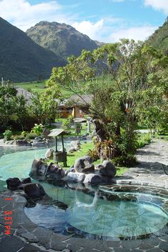 an outdoor hot tub surrounded by rocks and trees