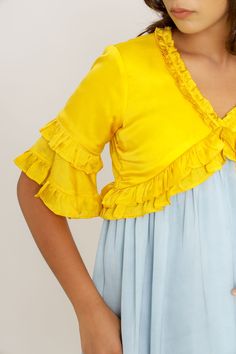 We are keen to introduce you to one of our exclusively picked brands from India - Neora by Nehal Chopra. The Hoppípolla Collection is a playful mix of color-blockings and variation in lengths and silhouettes. Read and see full collection here. Yellow-Ice Blue Mini Dress with Gathers and Frills in the Neck, Sleeves and Bottom. Fabric: Bemberg Modal Silk; woven via using Bamboo fabric on both the sides (Also known as Sustainable silk) Lining: Butter Crepe; Plant based with man made viscose The len Yellow Color Block Dress For Spring, Blue Color Block Party Dress, Blue Color Block Short Sleeve Dress, Chic Yellow Color Block Dress, Spring Blue Color Block Midi Dress, Color Block Short Sleeve Party Dress, Frill Dress, Fairytale Dress, Blue Mini Dress