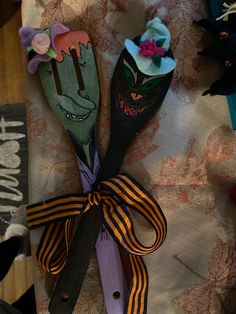 two wooden spoons decorated with halloween decorations