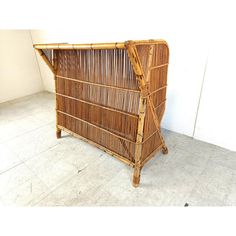 a bamboo bed frame sitting on top of a tile floor next to a white wall