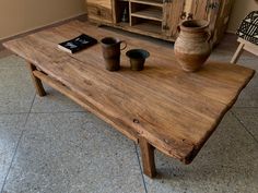 a wooden table with two cups on it and a book sitting on top of it