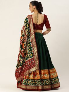 Get ready to turn heads this festive season with our alluring Green Patola Print Silk Festival Wear Lehenga Choli. This exquisite piece is designed to make you stand out and be the center of attention at any occasion or celebration.
The lehenga itself features a vibrant combination of green and maroon colors, creating a stunning visual impact. Made from fine tussar silk, the lehenga has a 3.40 meter flair, giving it a graceful and elegant silhouette. The stitching is impeccable, ensuring a perfe Patola Print, Green Lehenga, Lace Border, Maroon Color, Lehenga Choli, Festival Wear, Festive Season, V Shape, Silk Printing