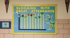 a bulletin board with flowers on it in a school classroom wall decorationating the words blooming with great attendance