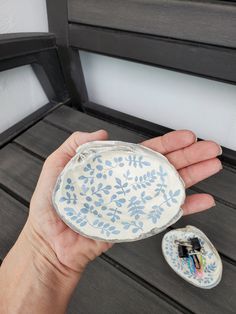 a hand holding a small blue and white plate