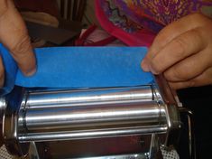 a person cutting paper with scissors on top of a machine