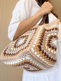 Crochet Granny Square Bag, Crochet Tote Bag for Women, Retro Bag, Hippie Bag, Summer Bag, Bohemian Style Beige Tote Bag, Women's Gift Bag, Crochet Beige Handmade Tote Bag 📌 The Colorful Crochet Granny Square Bag consist of 5 crochet motif pieces. The main color of the crochet bag is beige and it is fully lined inside. The bag can close also with a magnet. And it has a pocket 🌸🎁 Whether for yourself or as a thoughtful gift, our crochet tote bag is a stylish and practical choice for all occasions. 🌸🎁 Order Now to add a touch of handmade elegance to your everyday life or surprise someone special with a gift that combines beauty and functionality. >> BAG SIZE << Bag length: 24 cm Bag width: 39 cm Strap length: 26 cm Strap color: Dark Brown >> MATERIAL << %49 Cotton %50 Acrylic >> CARE INS Brown Square Crochet Bag For Shopping, Square Brown Crochet Shopping Bag, Brown Crochet Tote Bag With Granny Square, Brown Square Crochet Shopping Bag, Beige Bohemian Crochet Bag With Handles, Bohemian Beige Crochet Bag With Handles, Everyday Brown Crochet Bag With Granny Square, Beige Granny Square Crochet Tote Bag, Beige Granny Square Bag For Daily Use