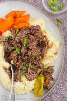 a white plate topped with mashed potatoes and meat