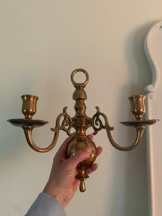 a person is holding onto a brass candelabra