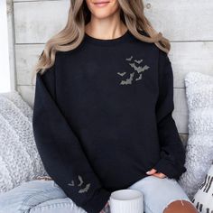 Embrace witchy charm with our Embroidered Bat Sweatshirt with bats on the sleeve too!. This goth-inspired, witchy delight features beautifully stitched celestial bats. A must-have for alt fashion lovers seeking a touch of whimsigoth clothing. Comfortable, stylish, and perfect for women who adore horror-inspired fashion. Check out more Halloween/Thanksgiving items here: https://www.etsy.com/shop/GrumpyGooseApparel?ref=seller-platform-mcnav&section_id=40090396 Browse through my other awesome items Fall Grunge Long Sleeve Sweatshirt, Grunge Long Sleeve Sweatshirt For Fall, Black Grunge Sweatshirt For Fall, Spooky Black Long Sleeve Top, Halloween Grunge Long Sleeve Sweater, Gothic Oversized Long Sleeve Tops, Oversized Long Sleeve Gothic Top, Spooky Black Long Sleeve Sweater, Spooky Long Sleeve Black Sweater